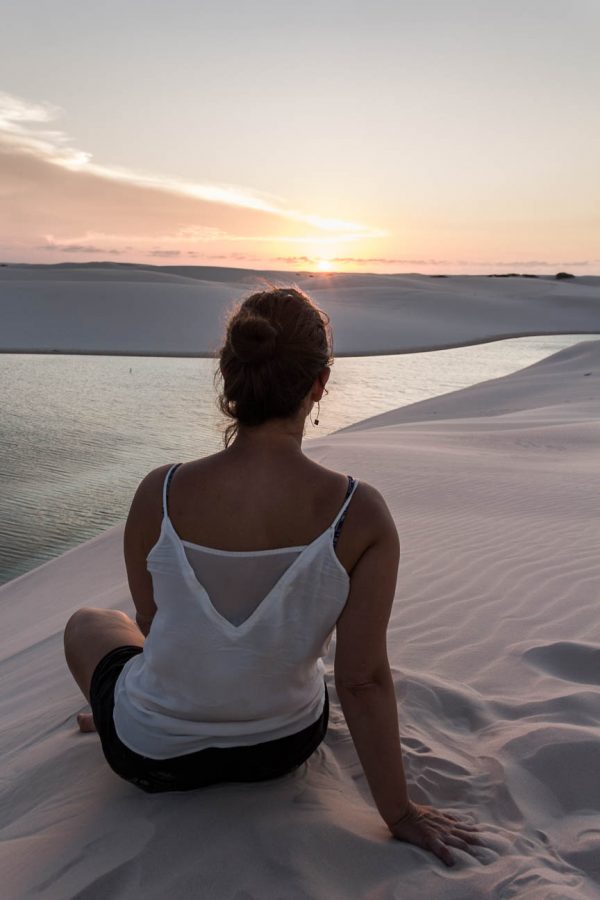 Une femme observe le coucher de soleil dans les dunes des Lençois Maranhenses - Route des Sensations